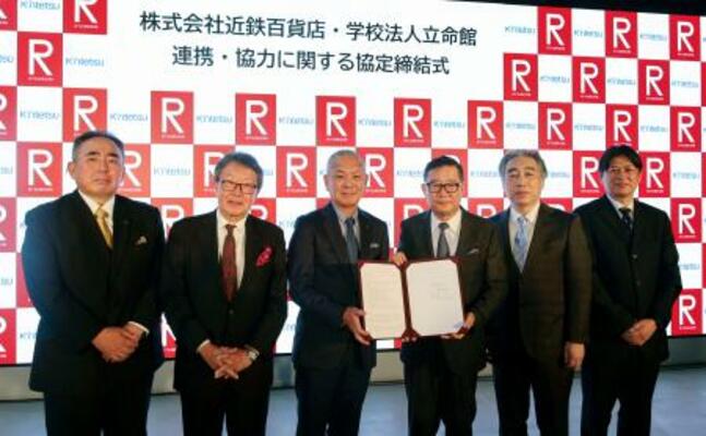 　連携協定の締結式に臨んだ近鉄百貨店の秋田拓士会長（左から２人目）と学校法人立命館の森島朋三理事長（右から３人目）ら＝３日、大阪府茨木市