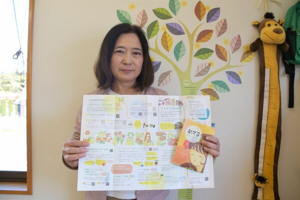 リーフレットを手にする「子育てほっとねっと」の西田理事長
