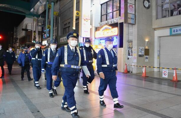 重点地区に指定されたオリオン通りをパトロールする警察官ら＝６日午前０時３５分、宇都宮市曲師町