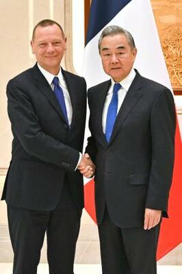 　握手するフランスのボンヌ大統領外交補佐官（左）と中国の王毅外相＝１５日、中国浙江省杭州市（新華社＝共同）