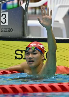 少年男子Ａ４００メートル個人メドレーで準優勝し、手を挙げて応援に応える松下＝18日午後２時30分、日環アリーナ栃木屋内水泳場