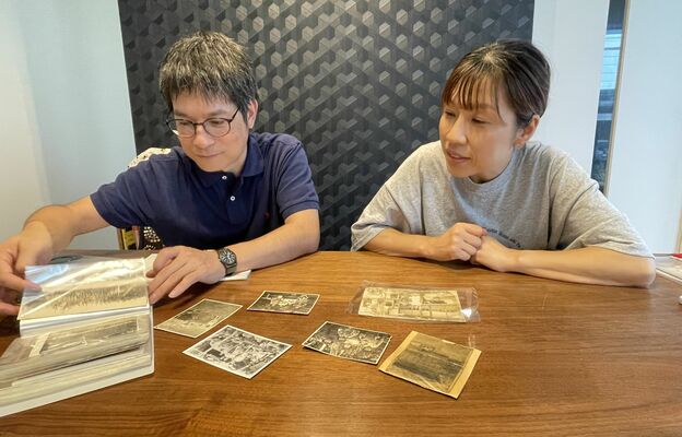 硫黄島で撮影された家族の写真を眺める田村さん（右）と西村さん＝９月下旬、那須町高久甲