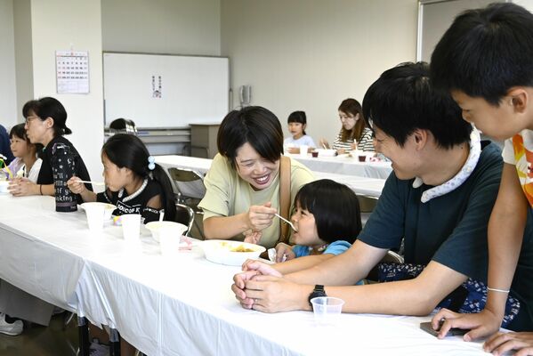 カレーライスを頬張る親子ら