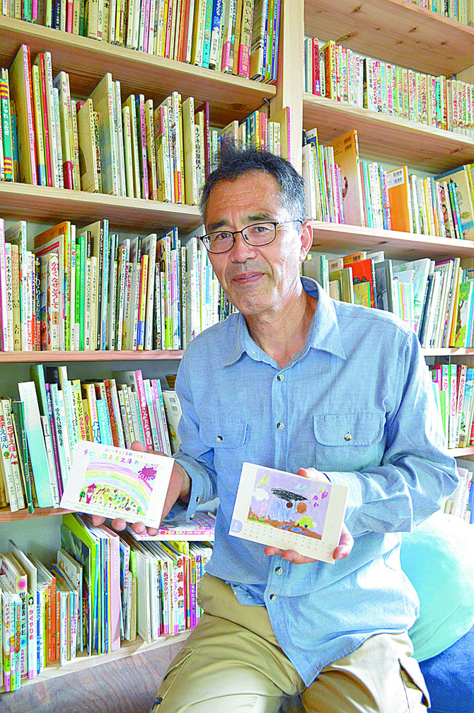 「ここは分館。本館は各施設の子どもたちの本棚です」。チビッコ未来文庫カレンダーを手に佐藤さん
