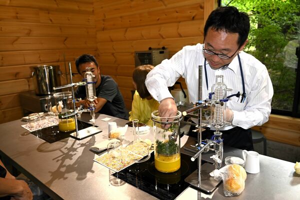 プレオープンの体験会で蒸留器に杉の葉を入れる参加者＝那須町