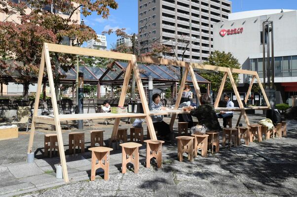 木製ロングテーブルで休憩する人たち