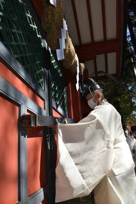 登拝門にかんぬきを掛ける中麿宮司