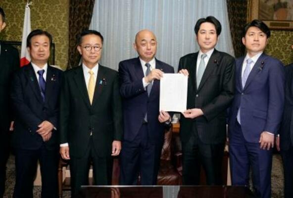 衆院の築山信彦事務総長(中央)に企業・団体献金の規制を強化する政治資金規正法改正案を提出する中道改革連合と国民民主党の議員=2日午後、国会