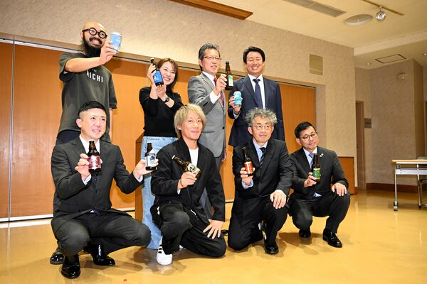 組合創立を祝い、クラフトビールを掲げる横須賀理事長（後列右から２人目）ら＝９日夕、宇都宮市