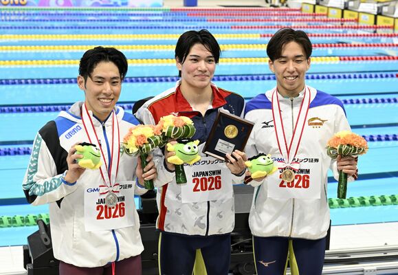 男子200メートルバタフライで初優勝し、記念撮影に応じる松下(中央、東洋大)=20日午後5時50分、東京アクアティクスセンター、森田大地撮影