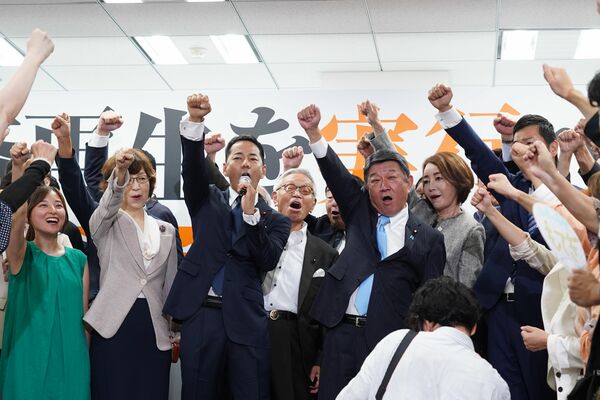 頑張ろう三唱で気勢を上げる茂木氏ら（左から５人目）ら＝12日午前、東京都港区