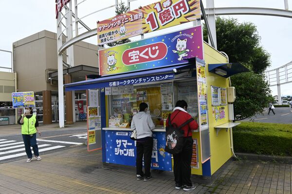 発売初日にサマージャンボ宝くじを買い求める人たち＝１１日午後、下野市下古山