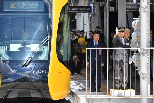 宇都宮に移って８年あまりの苦労が実り、ＬＲＴの開業式典で発車号令をかける中尾さん。白い手袋が光る＝宇都宮市宮みらいの宇都宮駅東口停留場