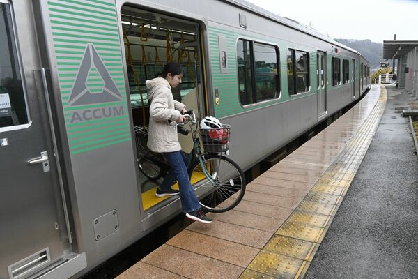 自転車と共に電車を降りる堀江さん