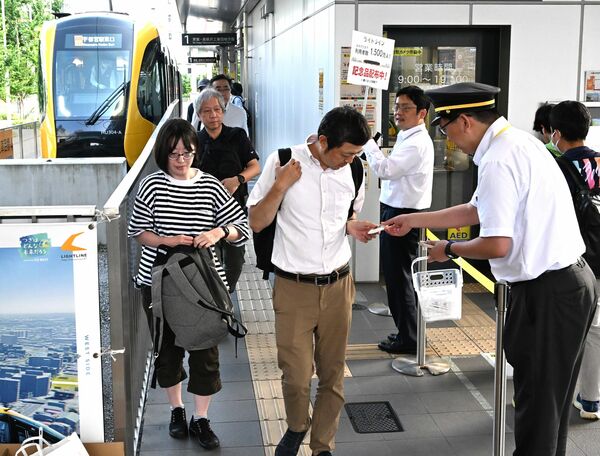 記念品を受け取るＬＲＴの利用者＝９日午後、宇都宮市宮みらい