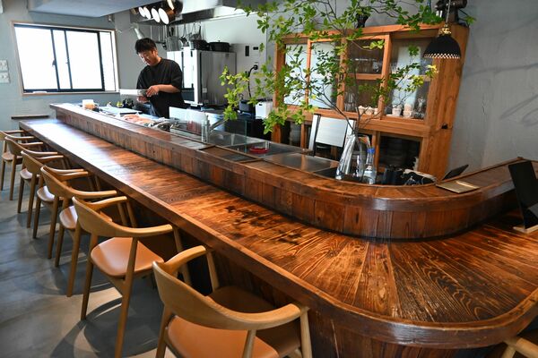 おでん屋から引き継いだ木製のカウンター（手前）と開店準備に追われる「音杢」の鈴木さん