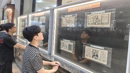 　「通貨史展」で展示された昔の紙幣を熱心に眺める来場者＝１月１７日、ホーチミン市