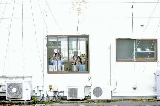 職場の窓からＳＬ大樹に手を振る会社員