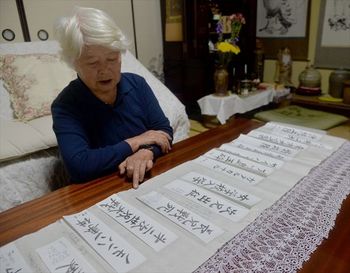 戦争当時の出来事や兄弟の出征時期などを記した年表を広げる田村行子さん。日中戦争、太平洋戦争を通じ、2人の兄が出征した=8日、野木町野木