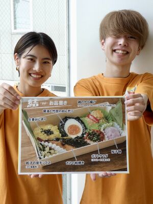 ＬＲＴ駅弁のお品書きを掲げる皆川雅斗さん（右）と松本彩花さん