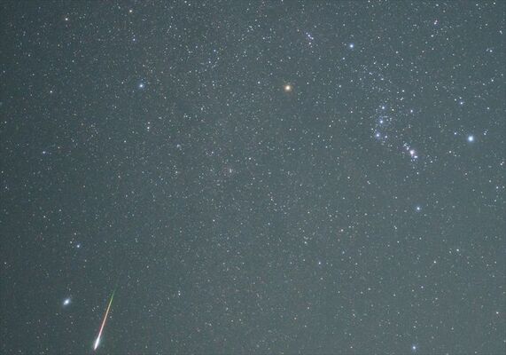 オリオン座（右上）と流星群の流星（左下）＝２２日午前０時５７分、小倉浩さん提供