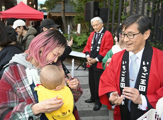 来場者にイチゴを配布する若菜社長(右手前)や福田知事(右奥)ら=31日午後、東京都渋谷区