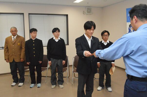 石塚署長（右）から感謝状を受け取る５人の高校生