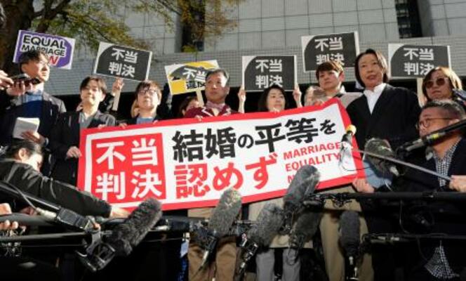 同性カップルら8人が国に損害賠償を求めた東京第2次訴訟の控訴審判決を受け「不当判決」などと書かれた紙を掲げる原告ら=28日午前、東京高裁
