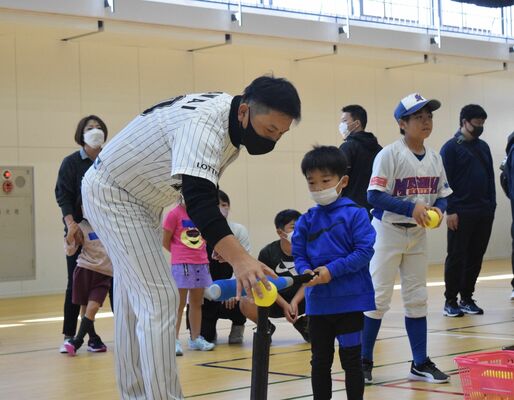 ティーを使った打撃練習をサポートする澤井さん（左）