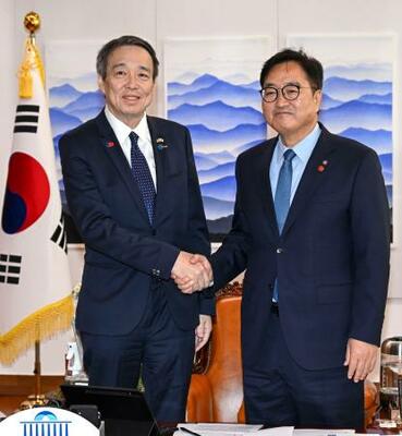 水嶋光一駐韓国大使(左)と握手する韓国の禹元植国会議長=8日、韓国国会(共同)