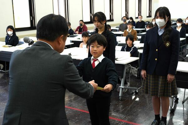 感想文コンクールで表彰状を受け取る受賞者ら=22日午前、県総合文化センター