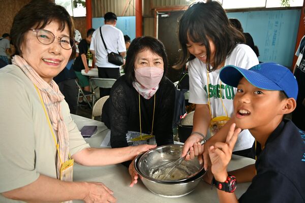 むらかみ牧場でアイス作りをする前田さん（右から１番目）と祖母敬子さん（同４番目）、友達の田中さん（同２番目）