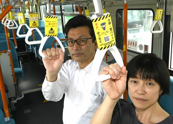 少年非行防止を訴えるつり革広告を握る宇都宮中央署の高橋修司署長ら＝４日午前、宇都宮市簗瀬４丁目