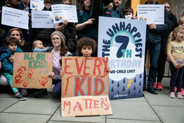 ツー・チャイルド・リミットの廃止を訴える親子連れや慈善団体の代表者ら＝４月上旬、ロンドン・労働年金省（エンド・チャイルド・ポバティ提供）