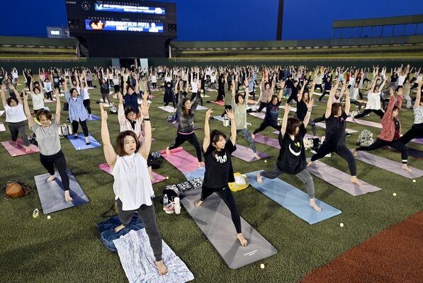 夜空の下、ヨガで汗を流す参加者たち＝８日午後７時25分、宇都宮市清原工業団地