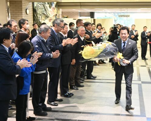 職員らが拍手で出迎える中、初登庁する佐藤市長