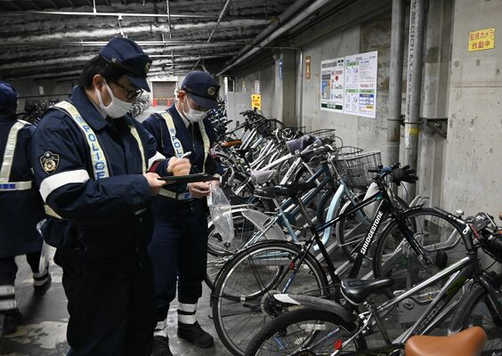 駐輪場で無施錠の自転車をチェックする宇都宮東署員＝２０２４年12月下旬、宇都宮市駅前通り１丁目