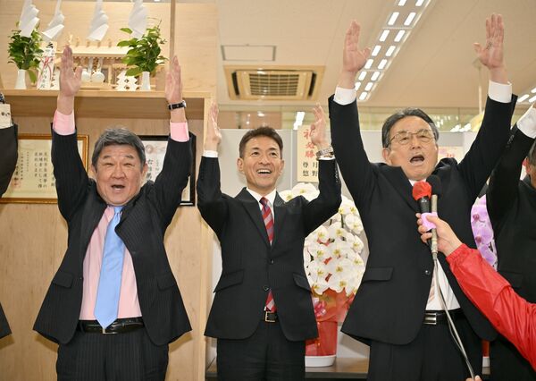 無投票で再選を果たし、万歳する早川尚秀氏（中央）＝13日午後５時５分、足利市南町、磯真奈美撮影