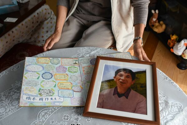 事故後に同僚らから贈られた寄せ書きと精作さんの遺影。生徒に慕われていたという＝２日午前、茂木町木幡