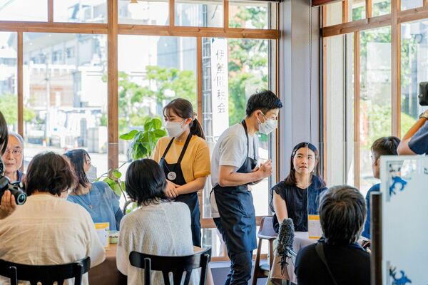 三重県伊勢市で開催された「注カフェ」で客と交流する若者たち（中央）＝２０２２年７月（奥村さん提供）