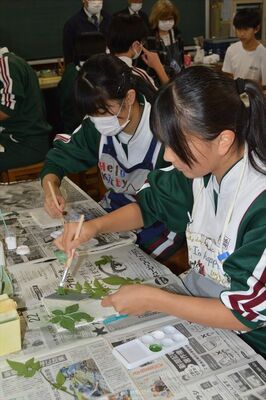 白い下地に色を付けてフレスコ画制作に取り組む生徒たち