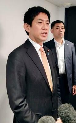 　記者団の取材に応じる小林元経済安保相＝２５日午前、東京都新宿区