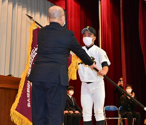 瀬端校長から選抜旗を受け取る石橋の横松主将＝石橋高体育館