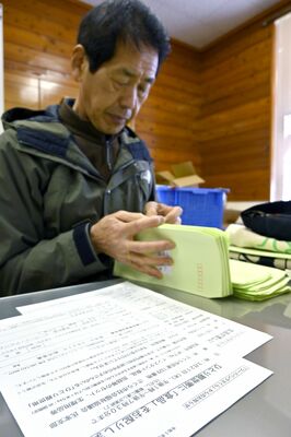 ひとり親世帯向けの食品配布会の案内通知の準備する君嶋さん。食料支援を契機に困窮家庭とつながることを目指す＝２月下旬、さくら市内