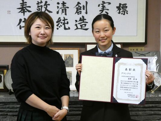 審査委員長の辻さん（左）から表彰状を受け取った真部さん