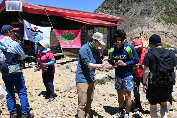 登山客にアンケートを行うメンバーら