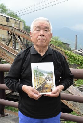 「親子三代足尾に生きて」を手にする上岡さん