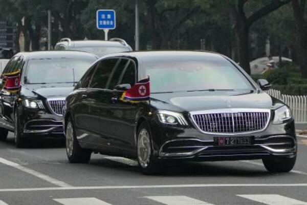 　北朝鮮の国旗を掲げ、北京市内を走る車列＝２日（共同）