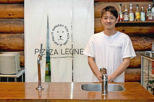 ログハウスの店内に立つ蒔田店長
