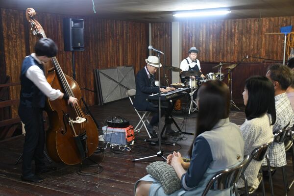 観客と同じ目線でエレキピアノを演奏するクニ三上氏（中央）＝５月17日、日光市